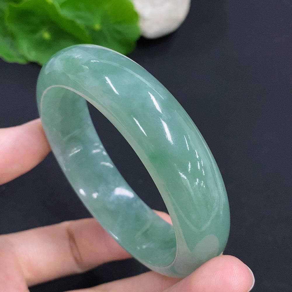 Jewelry image of a jadeite round bangle from HKHQ, weighing approx. 65.9g and size 55.5, showcasing smooth, polished jade surface.