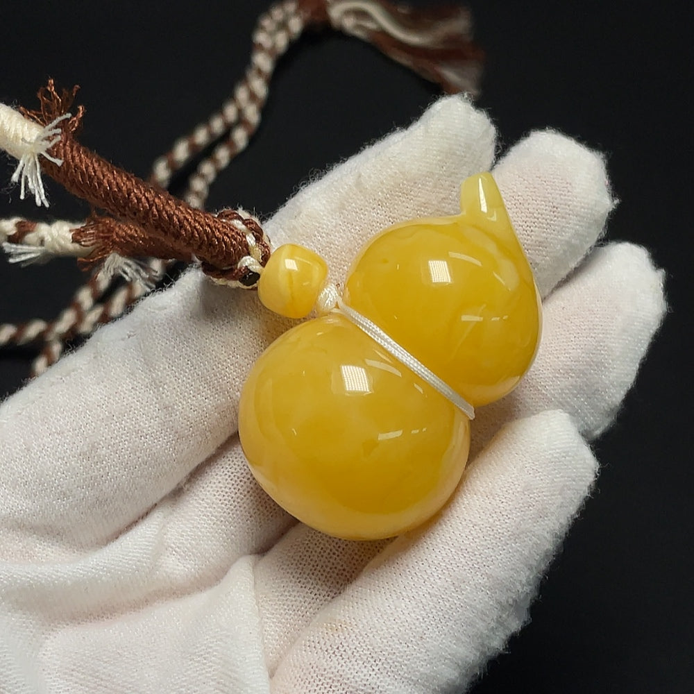 Amber beeswax pendant necklace from HKHQ featuring a warm, natural amber beeswax pendant on a delicate chain.