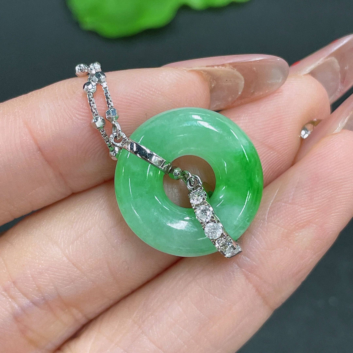 Jadeite pendant in 18k gold with diamond inlays, showcasing a smooth jade surface and intricate gold and diamond detailing.