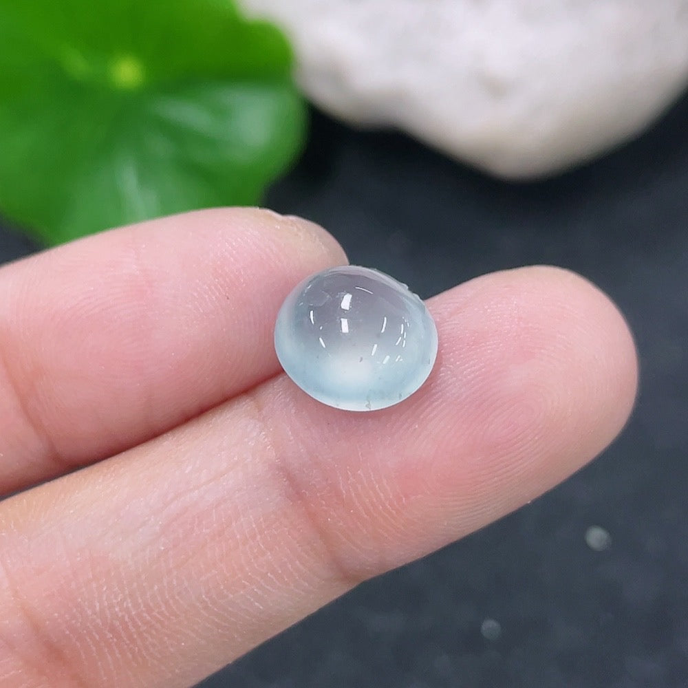 Close-up of a 0.71g jadeite cabochon jewelry piece from HKHQ, featuring smooth, polished green jadeite gemstone.