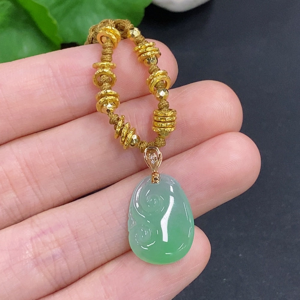 Jadeite Ruyi pendant with 18K gold accents, diamond details, showing smooth jade surface and elegant design, on a cord.