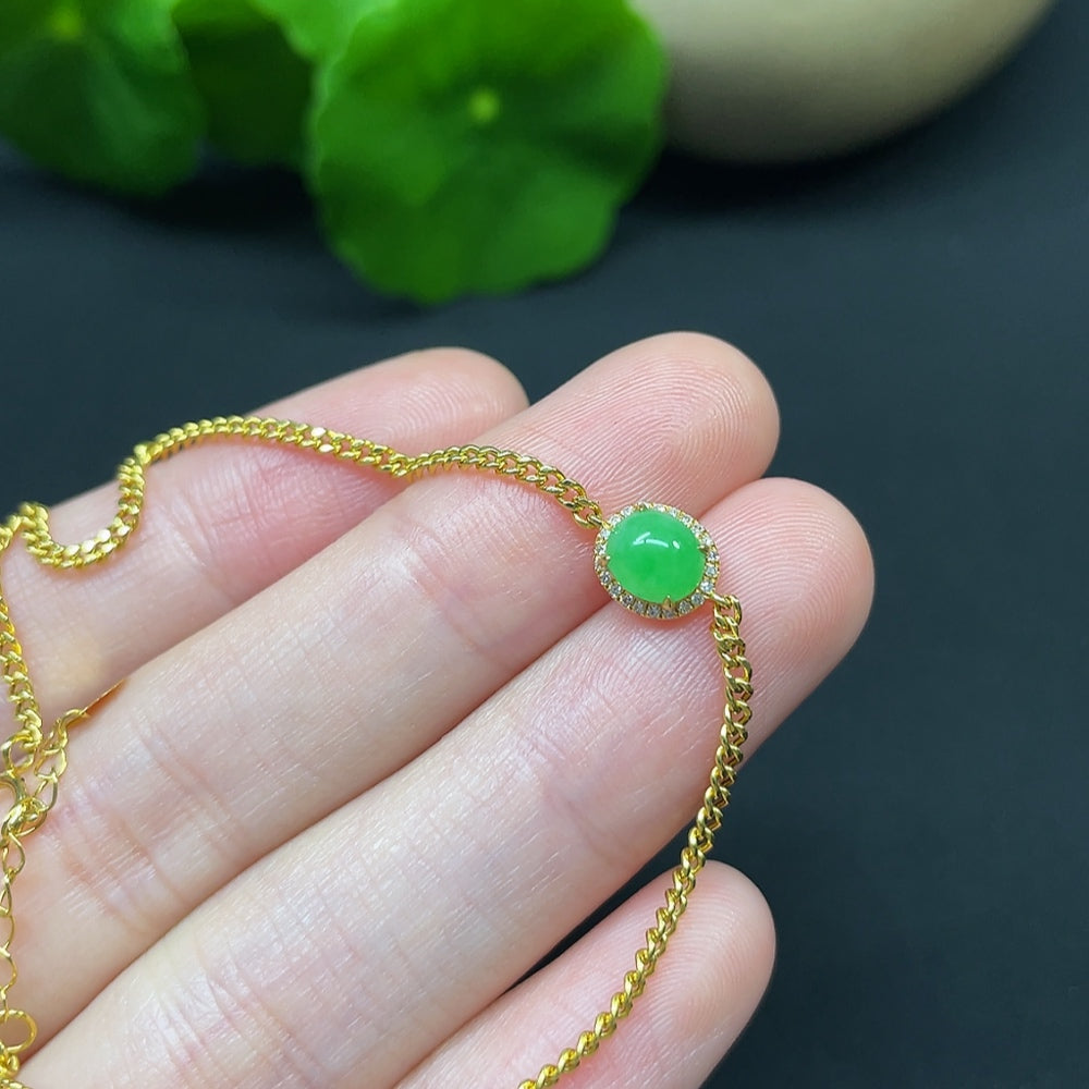 Jadeite cabochon bracelet by HKHQ featuring 18K gold band with diamond accents, displayed on a neutral background.