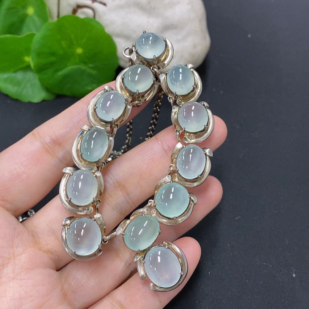 Jadeite cabochon gemstone in non-gold setting, weighing approximately 61.2 grams, with smooth polished surface and vibrant green color.