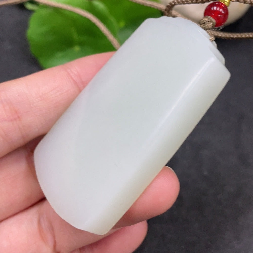 Huiliu certified Hetian jade pendant featuring a plain, smooth jade stone with natural green hues on a simple cord.