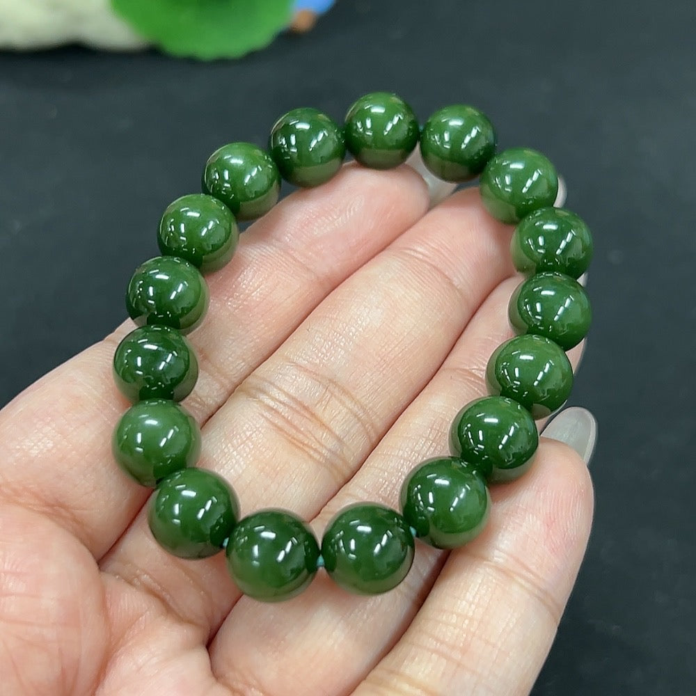 Hetian jade bracelet with approximately 10mm beads, weighing about 26.7g, showcasing smooth green jade stones.