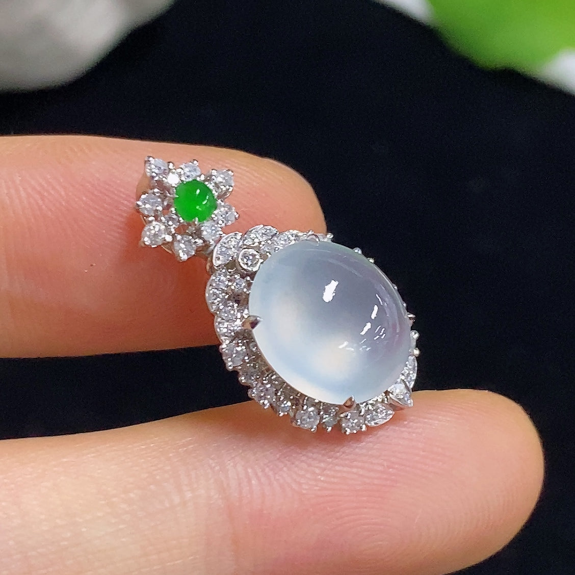 Jadeite pendant with 18K gold and diamond accents, featuring a polished green jadeite gemstone on a delicate necklace.