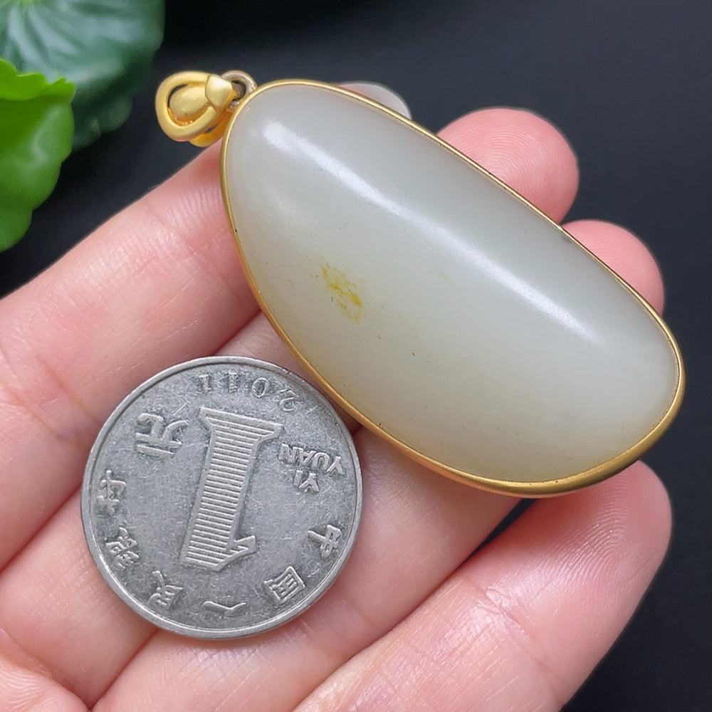 Hetian Jade inlaid pendant with 18K gold setting, weighing 25.95g, displayed on a necklace chain.