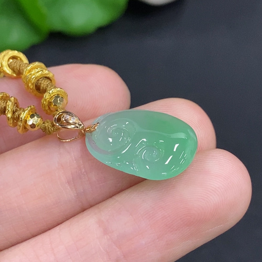 Jadeite Ruyi pendant with 18K gold accents and diamond details, featuring a smooth jade surface and a cord for wearing.