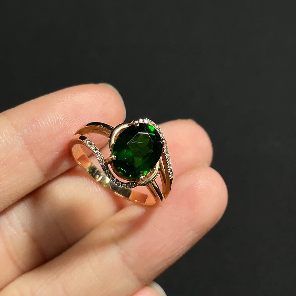Elegant diopside ring with diamond accents in 18K gold, showcasing a luxurious and intricate design.