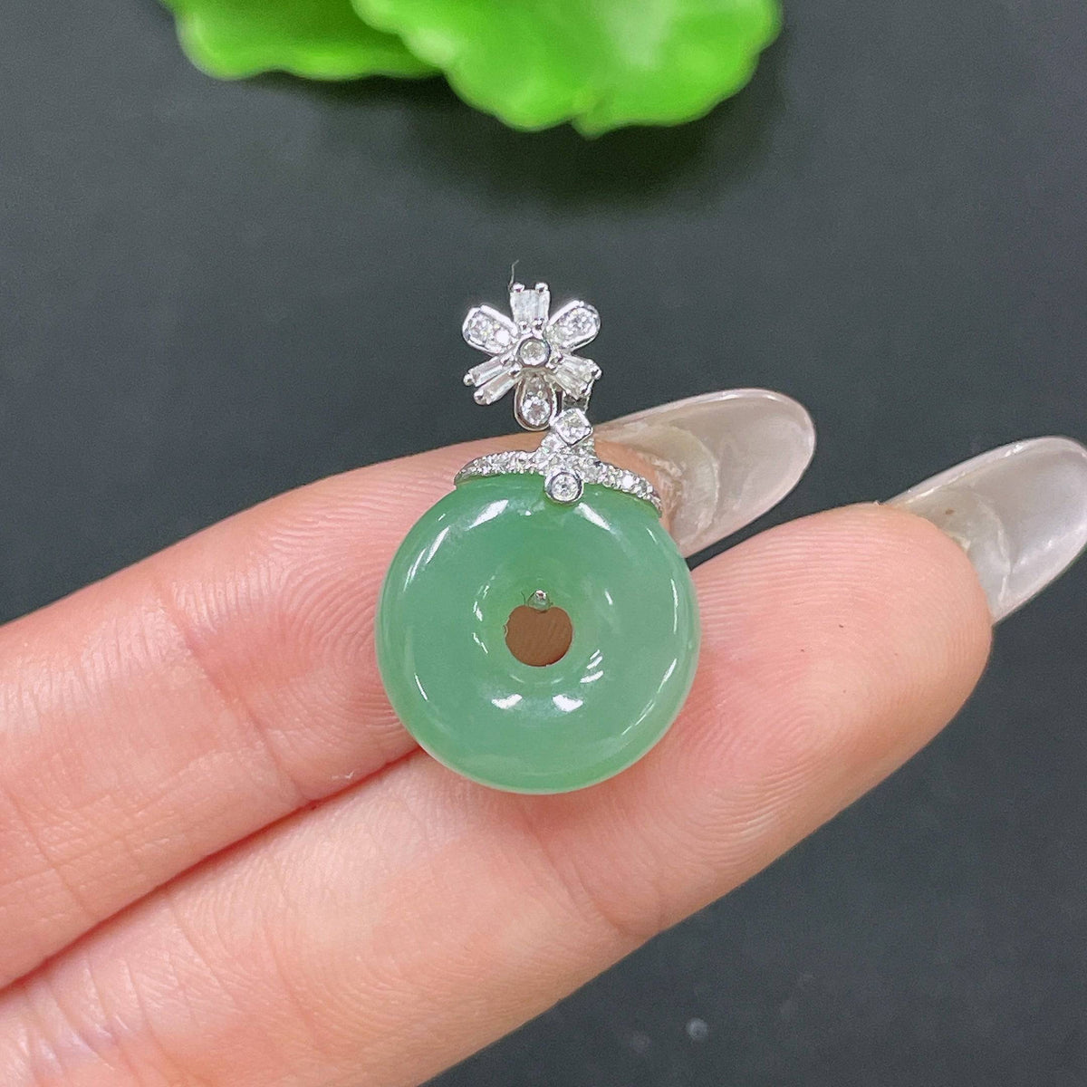 Jadeite pendant with peace knot design in 18k gold inlaid with diamonds, from HUILIU HQ, weighs approximately 3.47g.