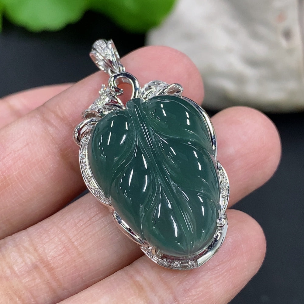 Jadeite leaf inlay pendant with 18K gold and diamond accents, displayed on a necklace chain, showcasing intricate craftsmanship.