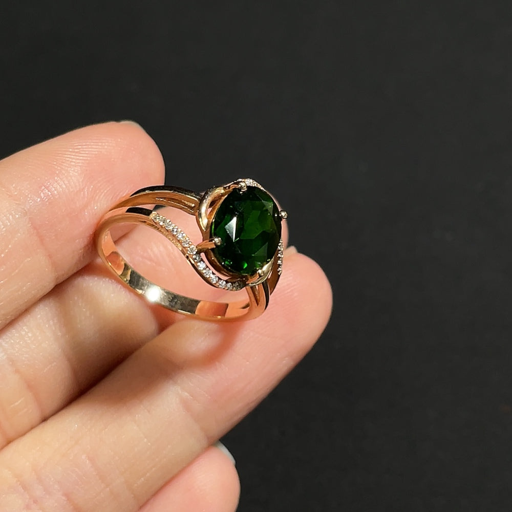 Diopside ring with diamond accents in 18K gold, featuring a polished band and sparkling gemstone setting.