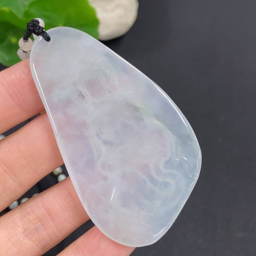 Jadeite Samantabhadra Bodhisattva pendant in green jade with detailed carving, hanging from a silk cord.