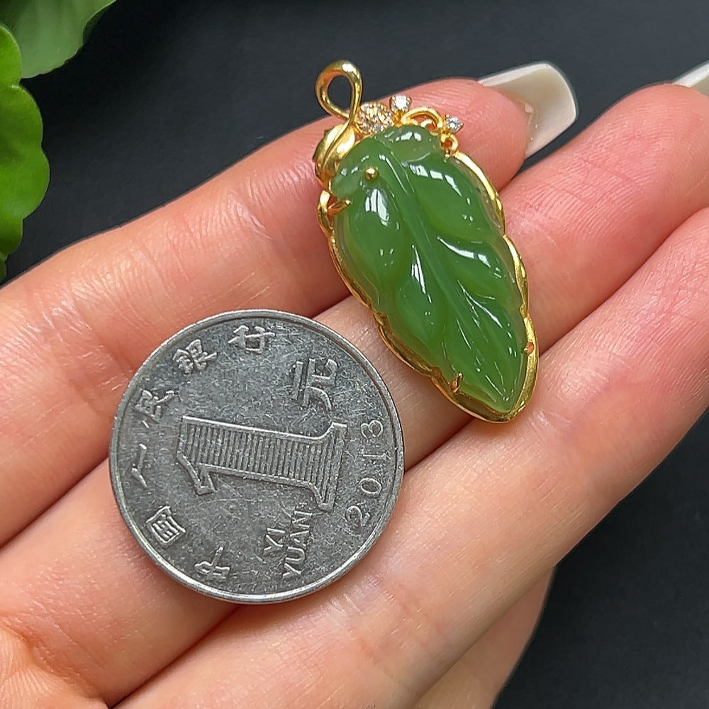 Green Hetian jade leaf pendant necklace with 18K gold setting, featuring a smooth, polished jade leaf design.