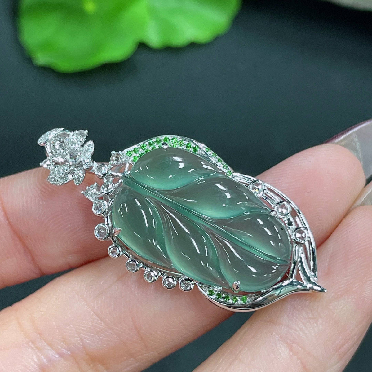 Jadeite pendant leaf with 18k gold inlay and diamond accents, crafted by HUILIU HQ, showcasing intricate details and elegant design.