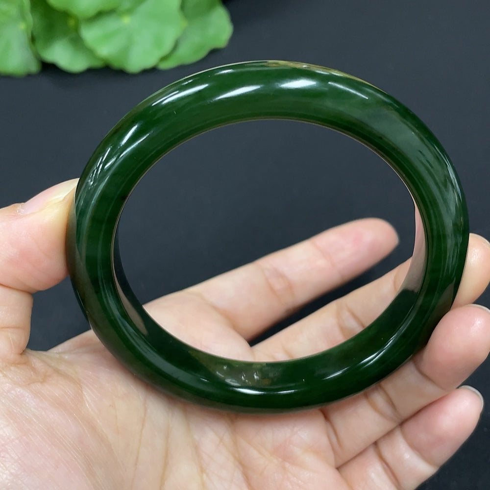 Green Hetian Jade round bangle bracelet from HKHQ, showcasing smooth polished jade with a glossy finish.