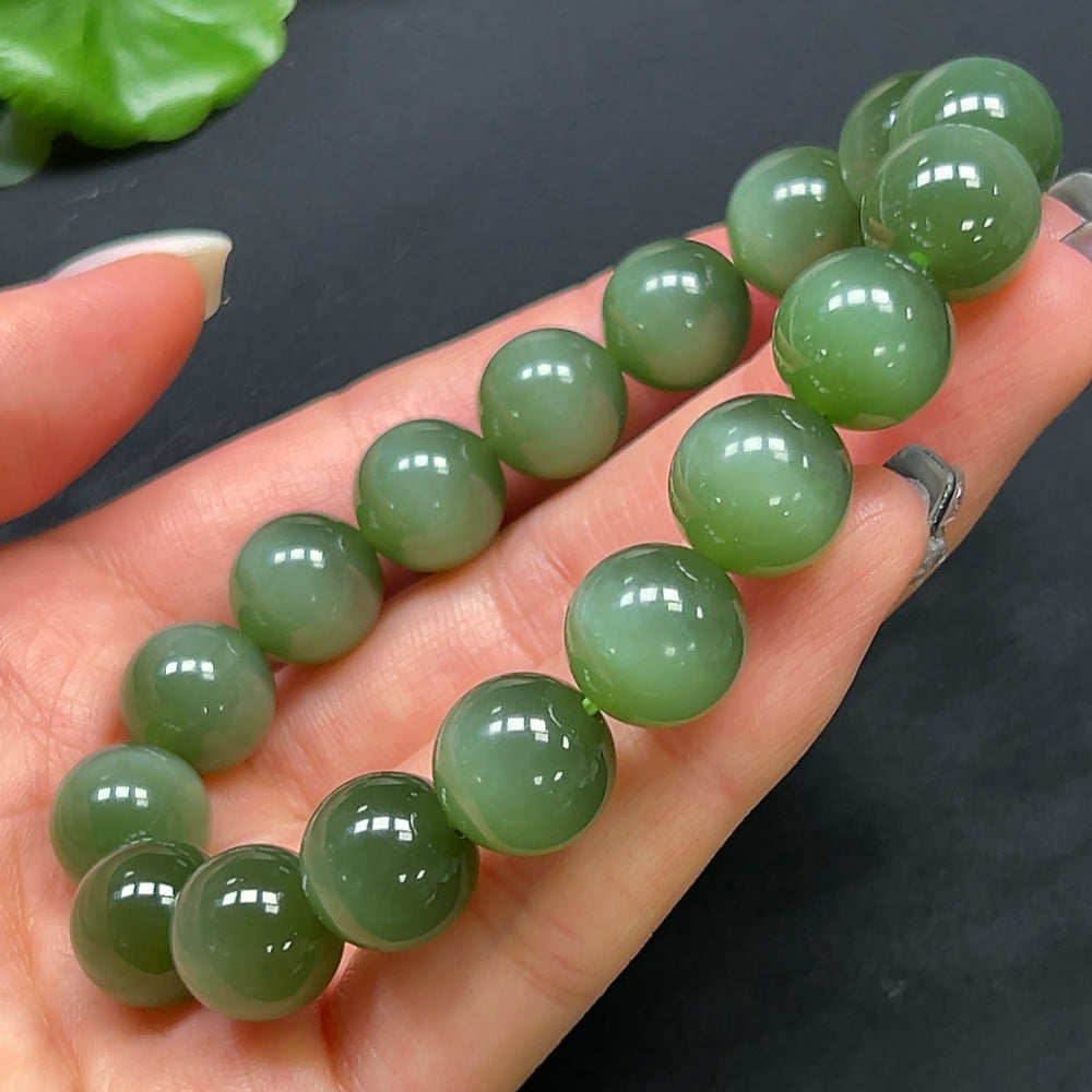 HKHQ Hetian Jade bracelet featuring 11.8mm smooth, polished jade beads on a delicate elastic cord.