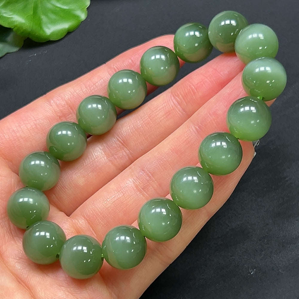 Hetian jade bracelet by HKHQ featuring 11.8mm smooth, polished jade beads on a flexible cord.