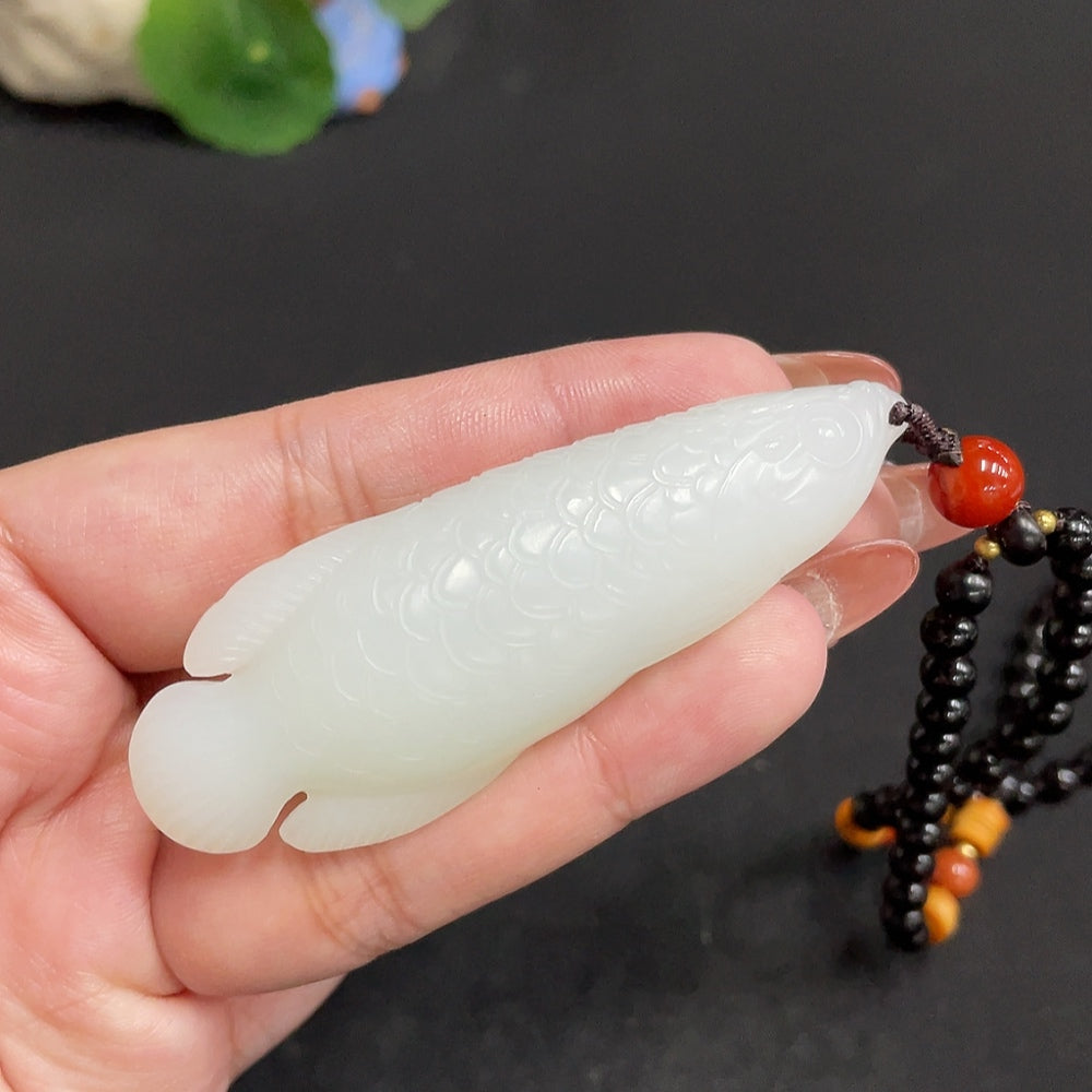 Huiliu certified Hetian jade pendant with annual surplus, showcasing smooth, polished green jade with intricate carving details.