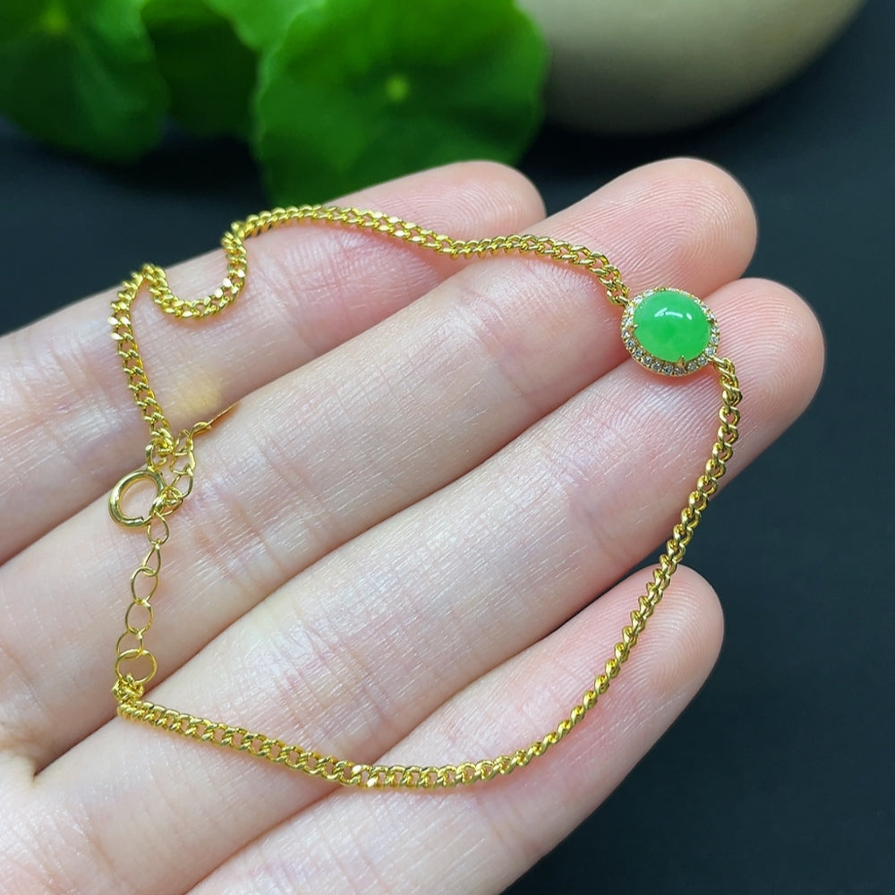 Jadeite cabochon bracelet by HKHQ with 18K gold band and diamond accents, showcasing a smooth, polished jadeite gemstone.