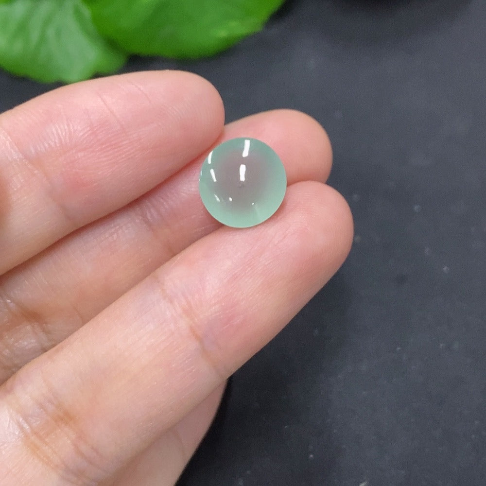 Elegant jadeite cabochon jewelry piece from HKHQ, showcasing a smooth, polished green gemstone on a neutral background.