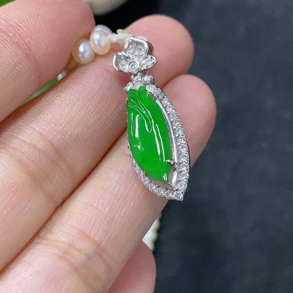 Jadeite freeform inlay pendant with 18K gold accents on a non-grade A chain, weighing approximately 12.1g.