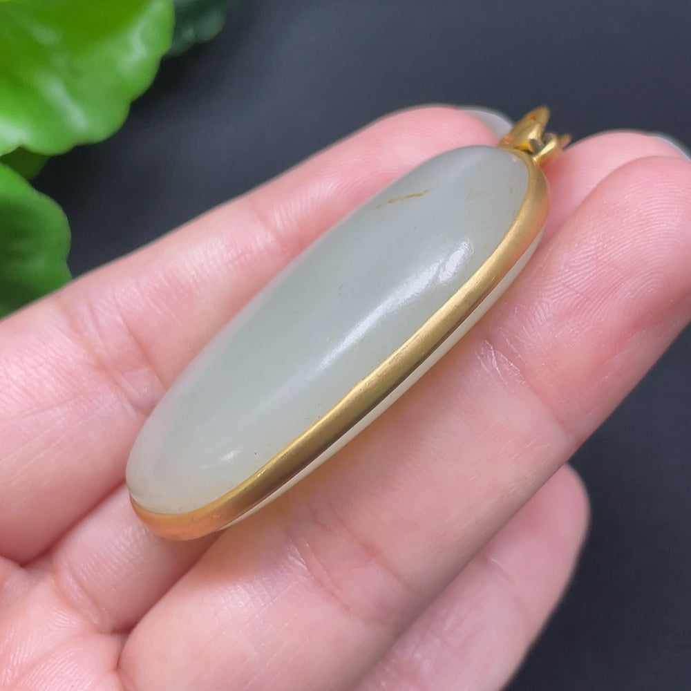 Hetian jade inlaid pendant on 18K gold necklace, crafted by HKHQ, showcasing intricate design and smooth jade surface.