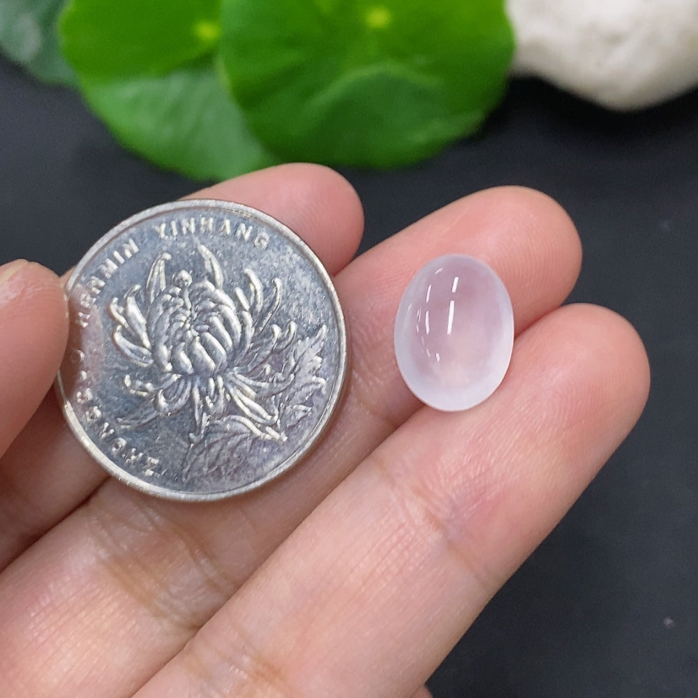 Close-up of a 1g jadeite cabochon jewelry stone with smooth, rounded surface, showcasing vibrant green color and polished finish.