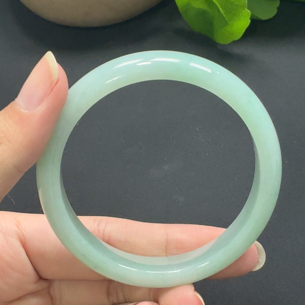 Jadeite round bangle in size 55.8, weighing approximately 45.69g, showcasing smooth, polished green jade with a glossy finish.