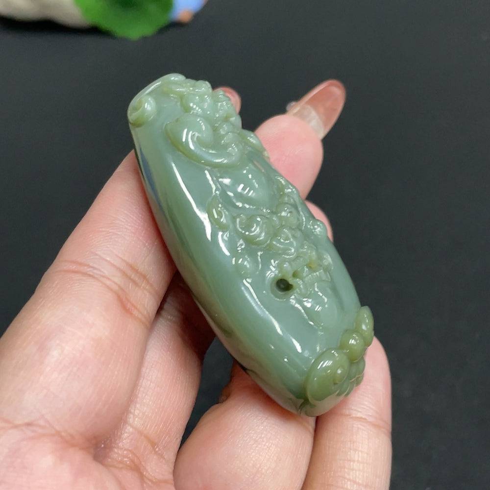 Huiliu certified Hetian jade pendant featuring an auspicious beast design, showcasing intricate craftsmanship and smooth jade surface.