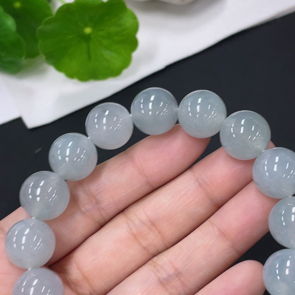 Huiliu certified jadeite bracelet with 12.8mm smooth, polished jade beads, showcasing elegant craftsmanship and vibrant green color.