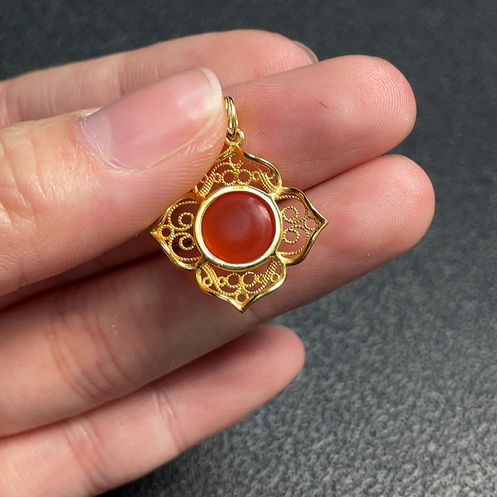 Red Agate gemstone pendant from HUILIU HQ with polished, teardrop shape and vibrant red color, set against a neutral background.