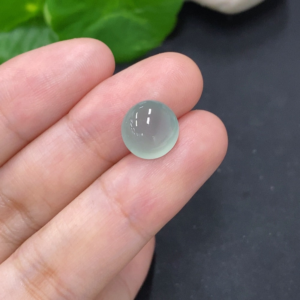 Small jadeite cabochon jewelry piece from HKHQ, showcasing smooth, polished green gemstone with natural luster and elegant shape.