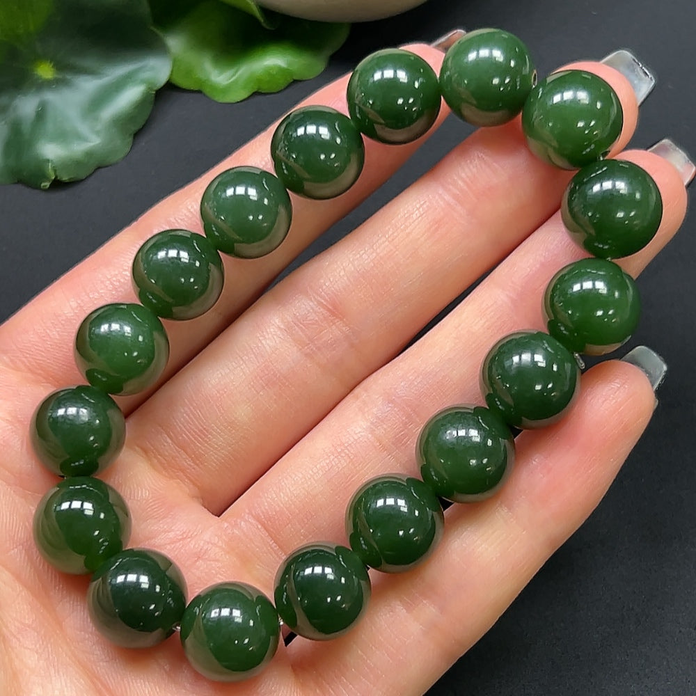 Hetian Jade bracelet with 12mm beads, roughly 44g, featuring smooth, polished green jade stones on a string.