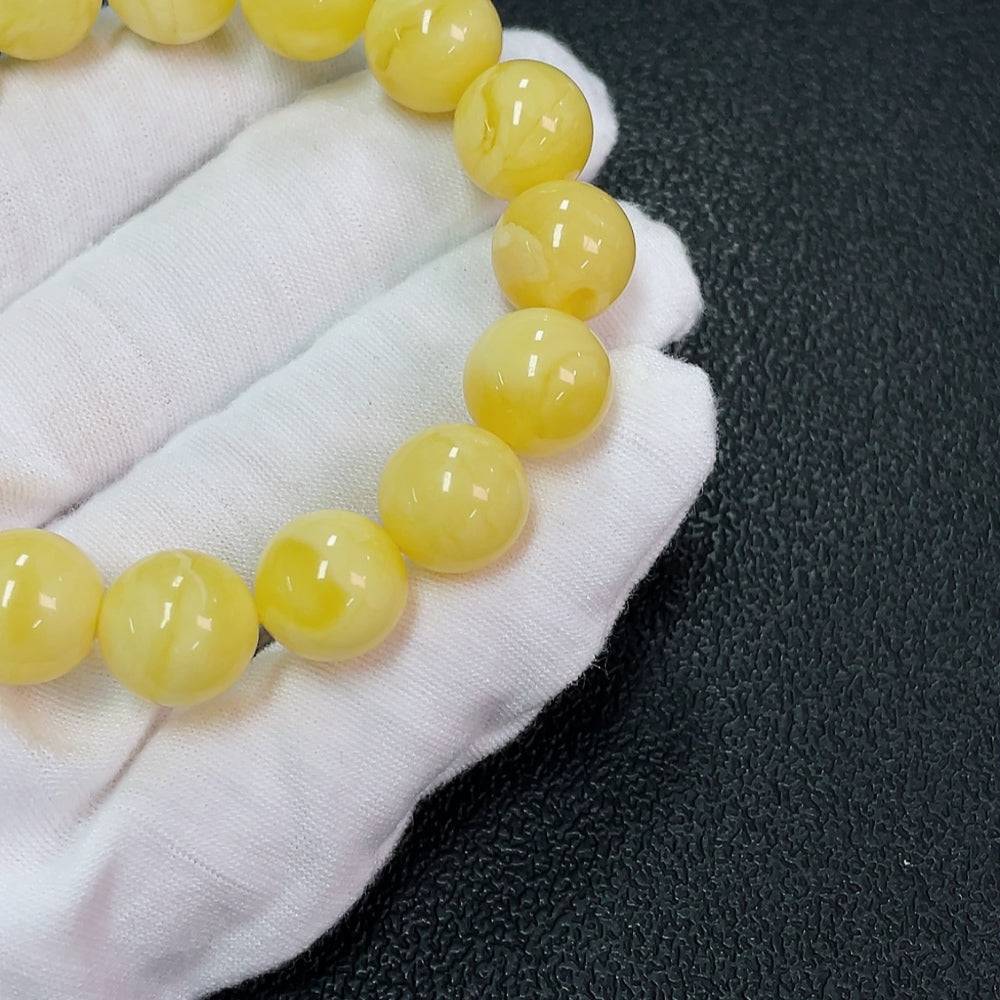 Huiliu amber beeswax bracelet with 12.2mm beads, natural amber color, showcasing smooth, polished beads and unique organic texture.