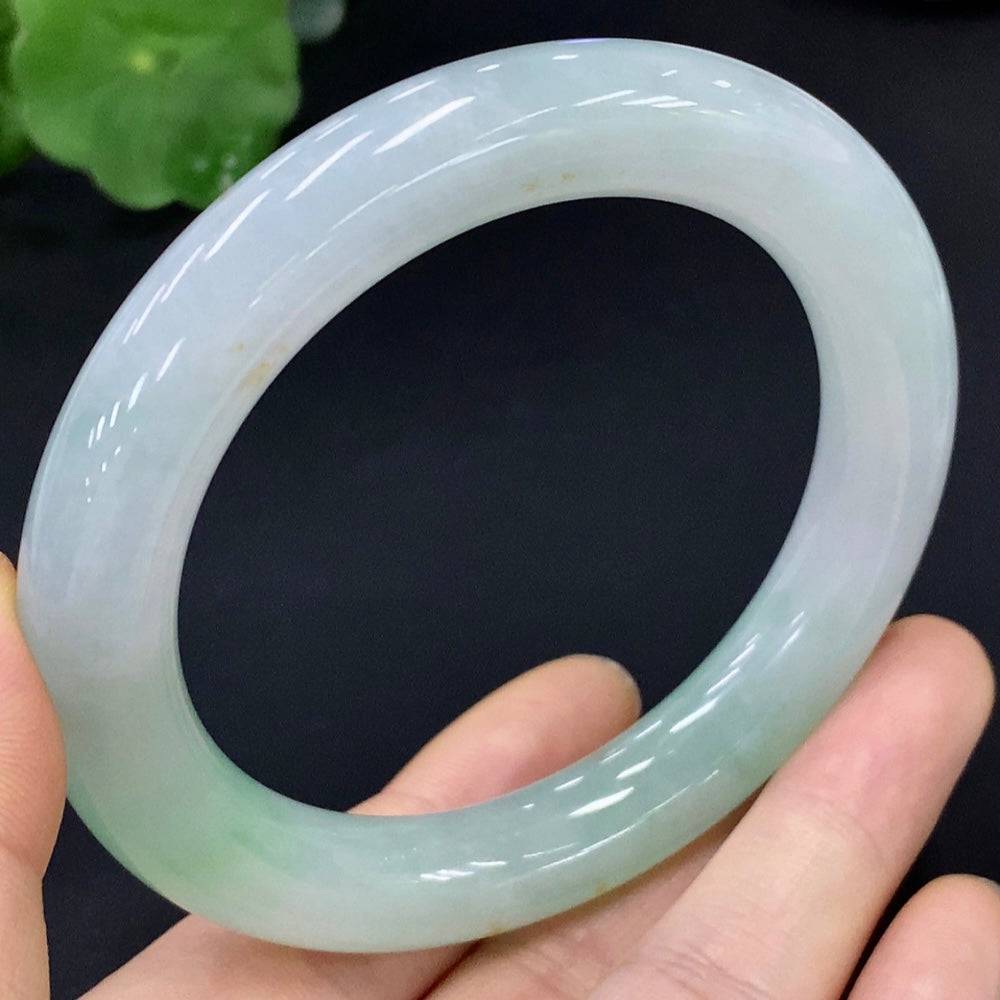Huiliu certified jadeite round bangle, smooth green jade jewelry, detailed close-up showcasing polished surface and craftsmanship.
