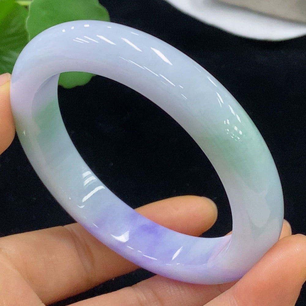 Jadeite bangle from HKHQ, size 59.3, weighing approximately 70.2g, showcasing smooth, polished green jade with intricate carvings.