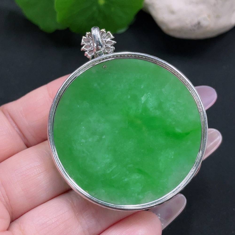 Jadeite pendant with 18K gold setting and diamond accents, showcasing smooth green jade stone on a jewelry display.