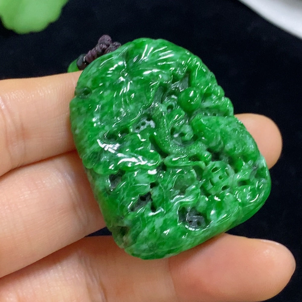 Jadeite landscape pendant with mineral inclusions, featuring a detailed design and attached rope, weighing approximately 30.56g.
