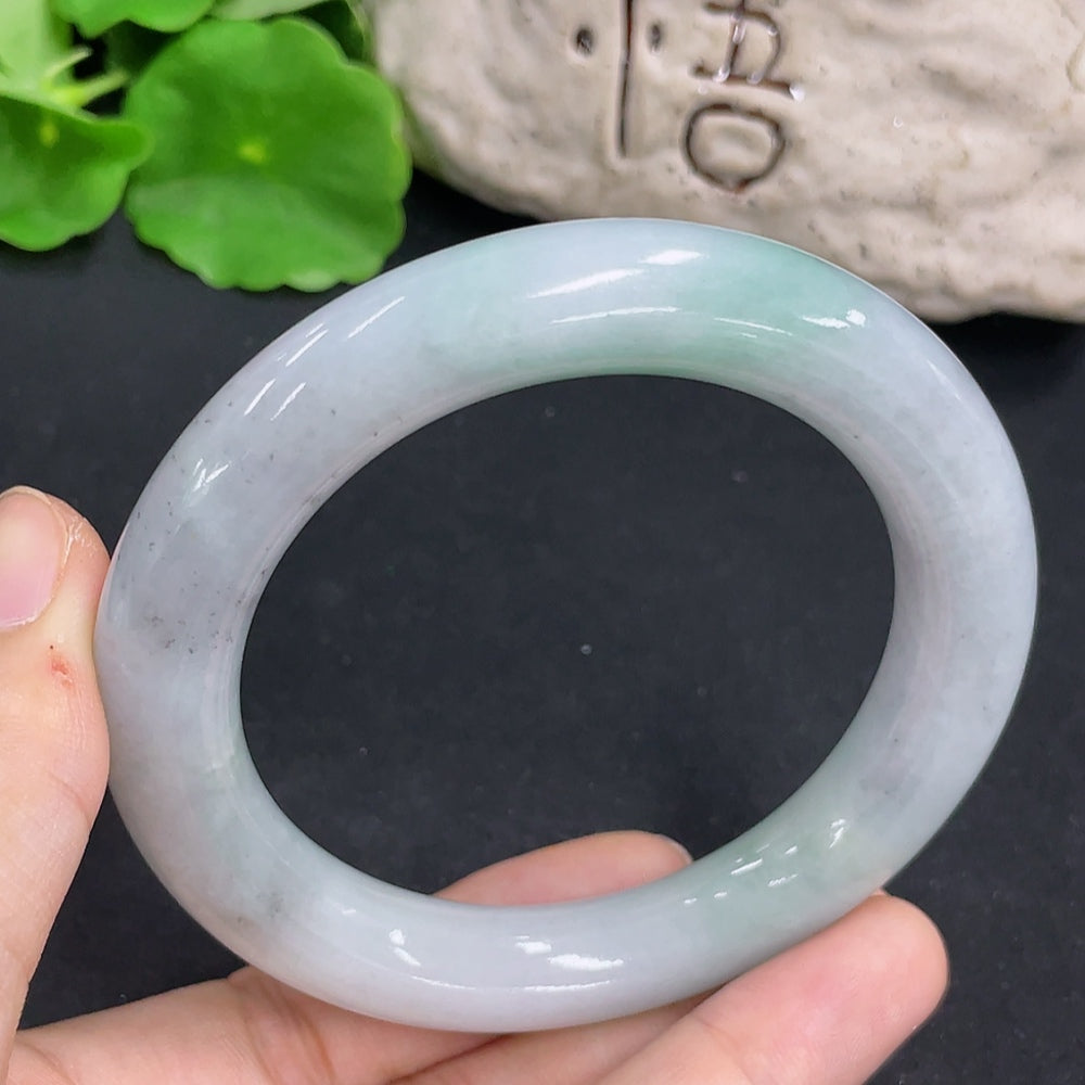 Elegant jadeite round bangle from HKHQ showcasing smooth, polished green jade with a shiny finish.