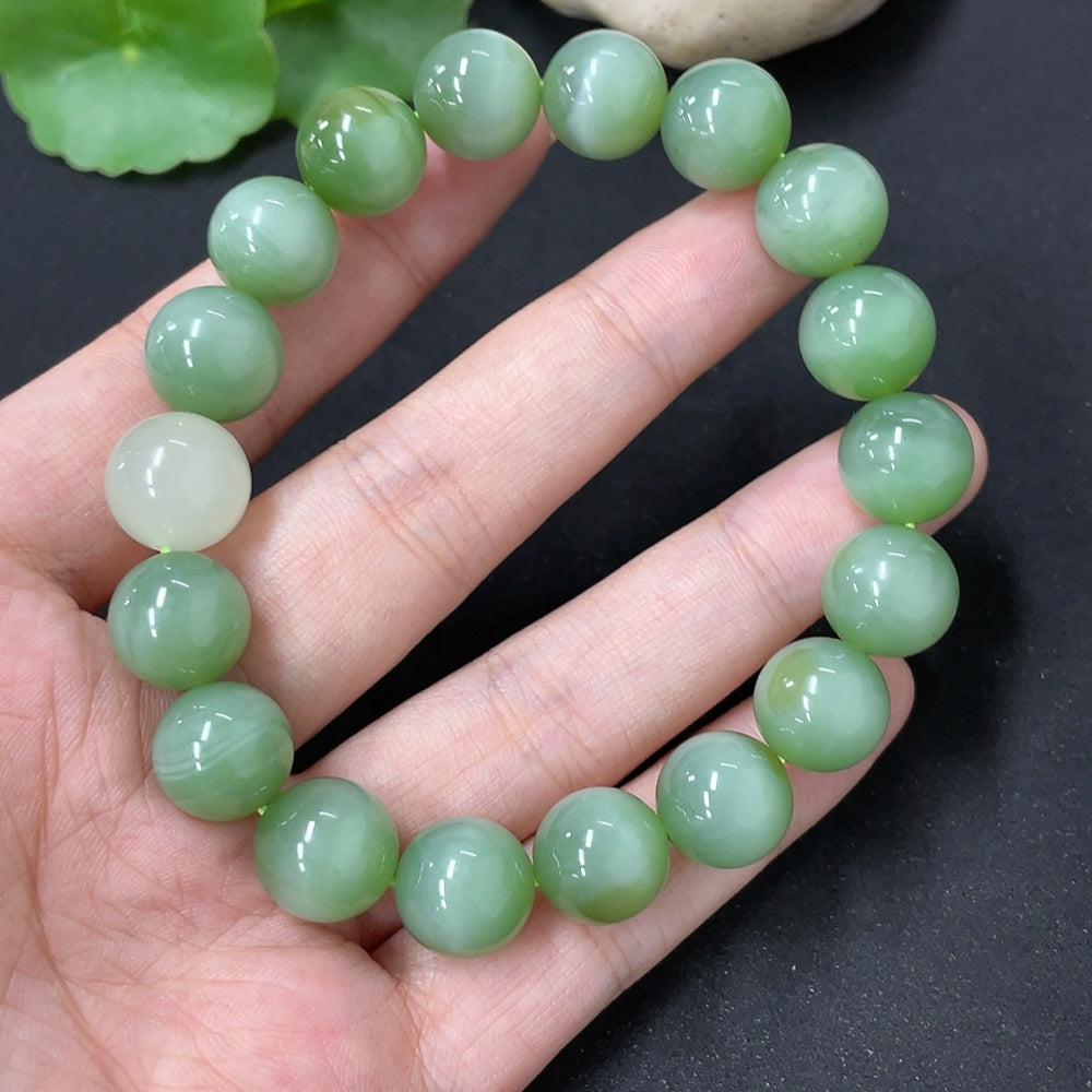 HKHQ Hetian Jade bracelet with smooth bead strands, showcasing elegant green gemstones on a neutral background.