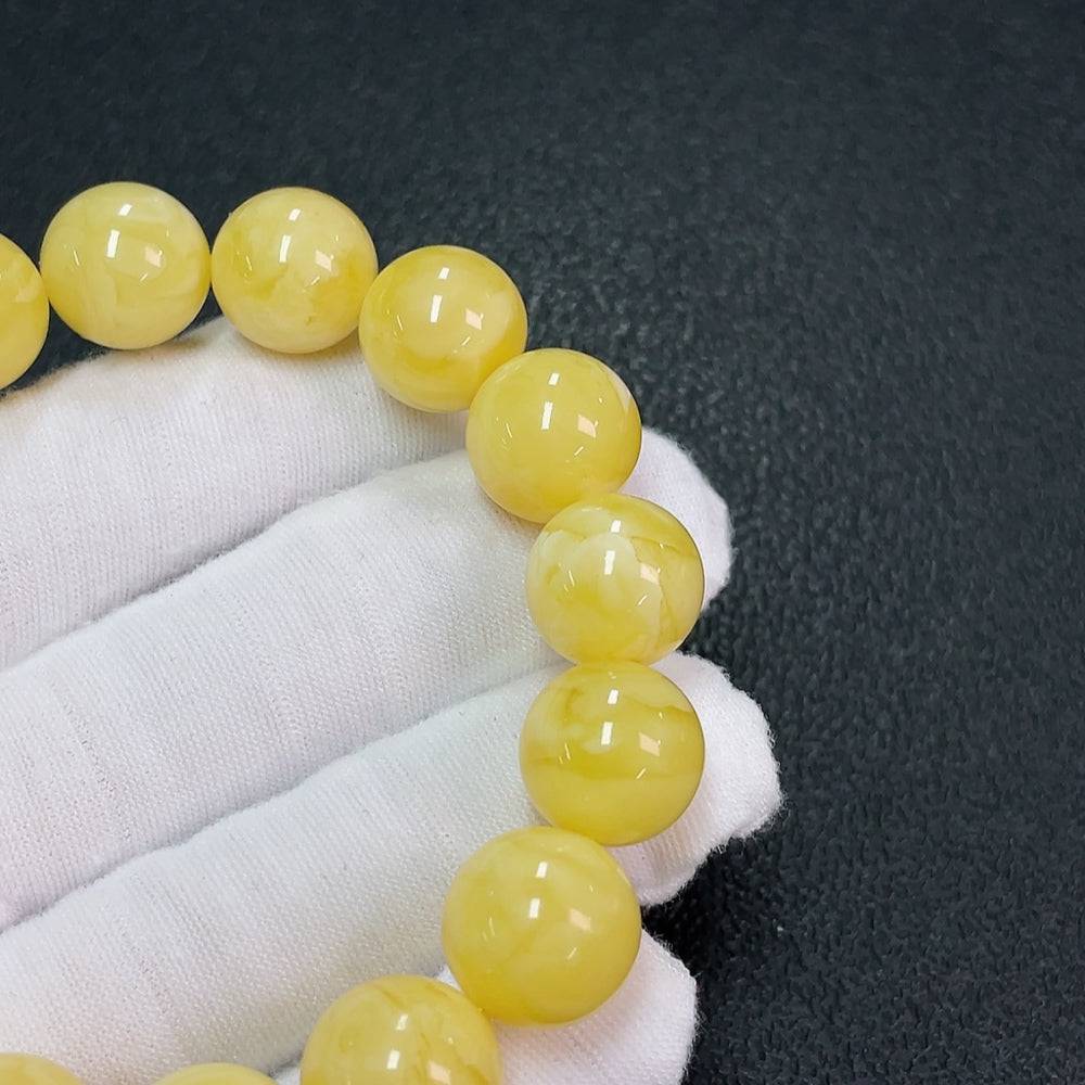 Huiliu Amber Beeswax Bracelet with 13.1mm beads, natural amber jewelry, showcasing warm honey-colored beads on a string.