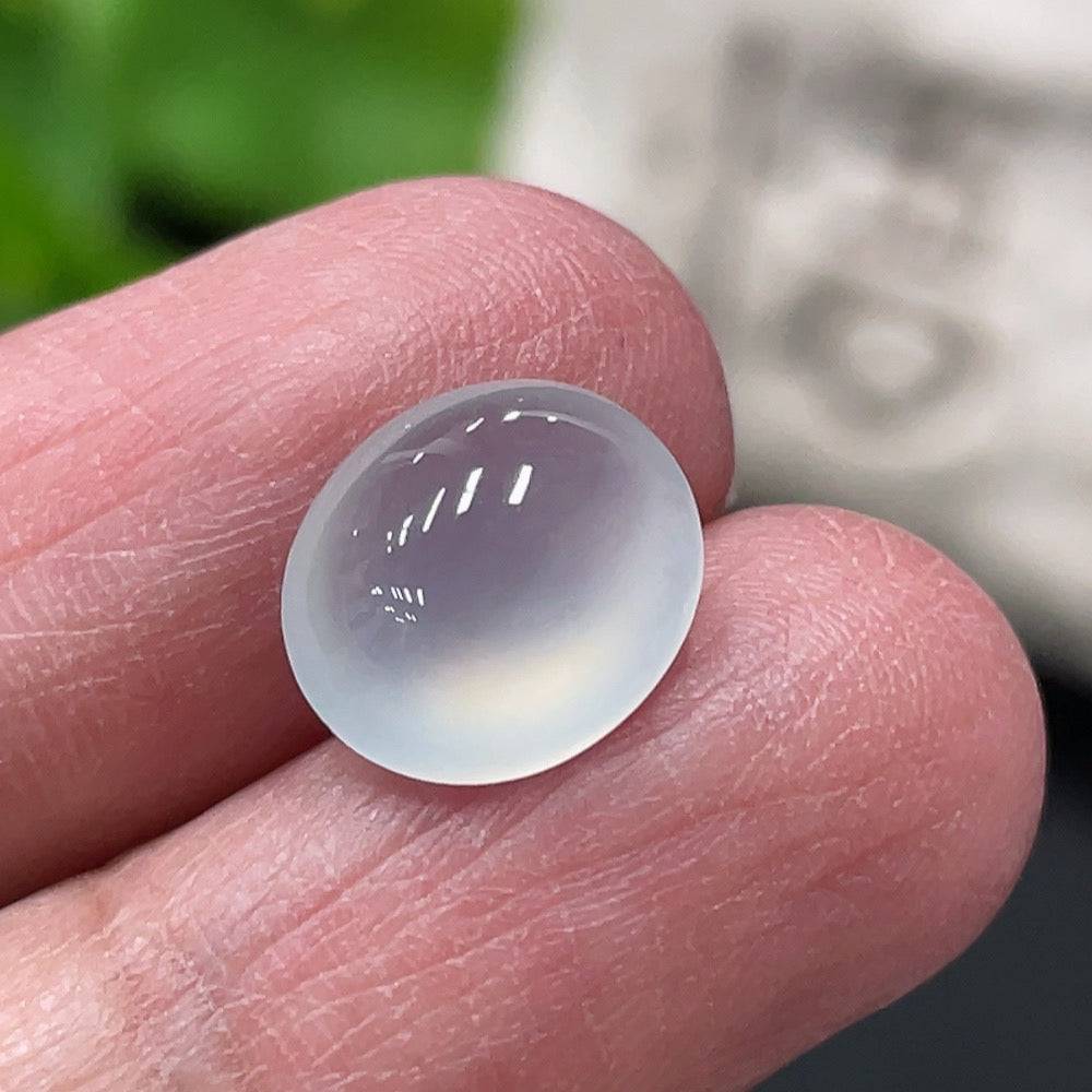 Green jadeite cabochon from HUILIU HQ, smooth polished surface, total weight approx. 0.73g, showcasing vibrant jade color and natural luster.