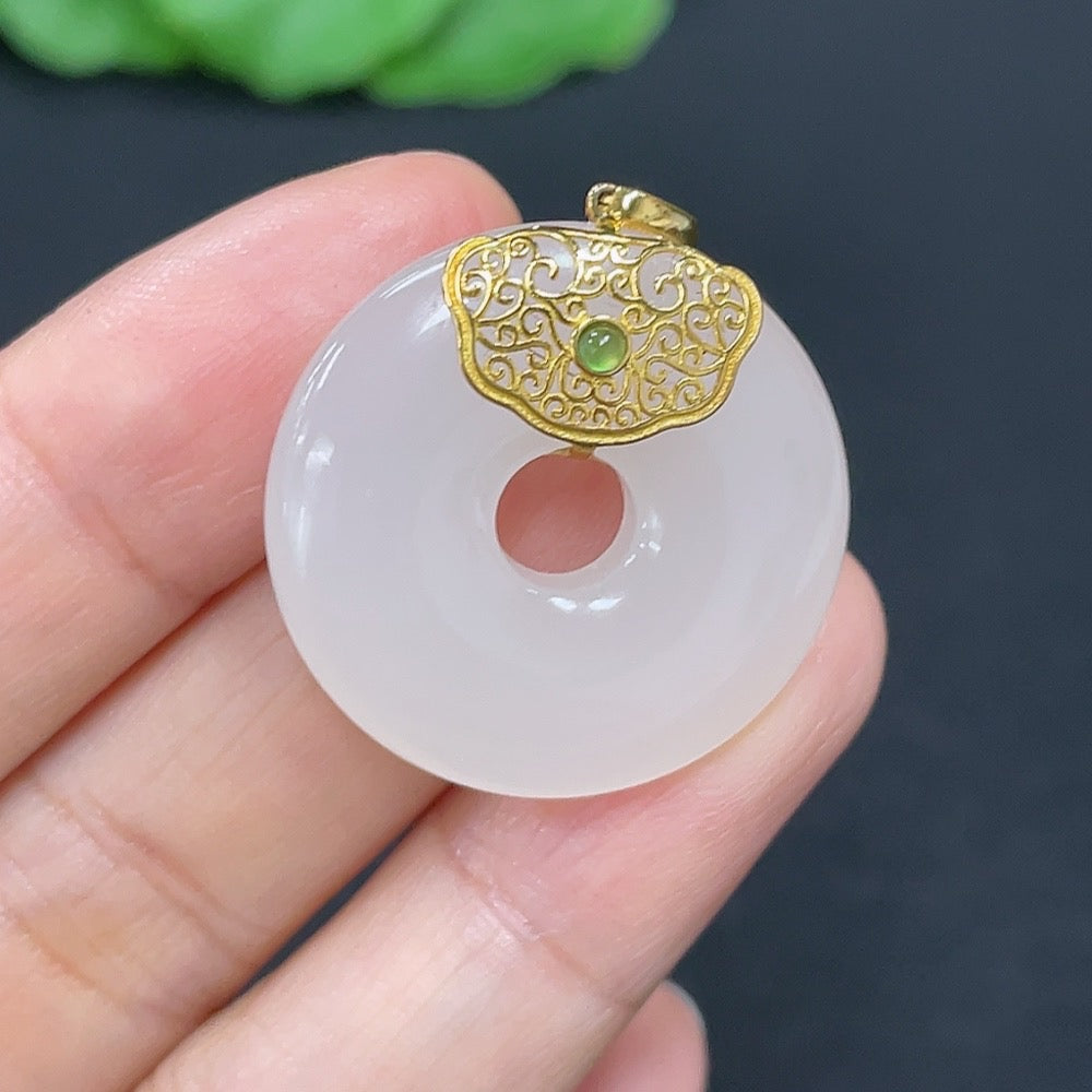 Hetian jade inlaid pendant donut necklace with 18K gold setting, featuring intricate design and bright green jade stone.