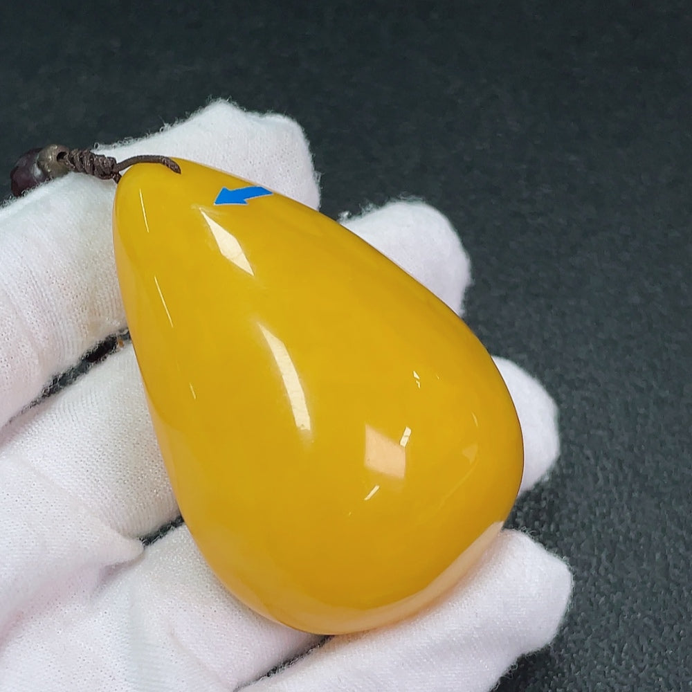 Amber and beeswax pendant with garnets, showing visible partial repairs, non-gold setting, gemstone details, weight around 79g.