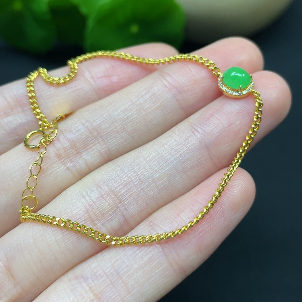 Jadeite cabochon bracelet by HKHQ with 18K gold and diamond accents, showcasing a smooth green jade stone and elegant design.