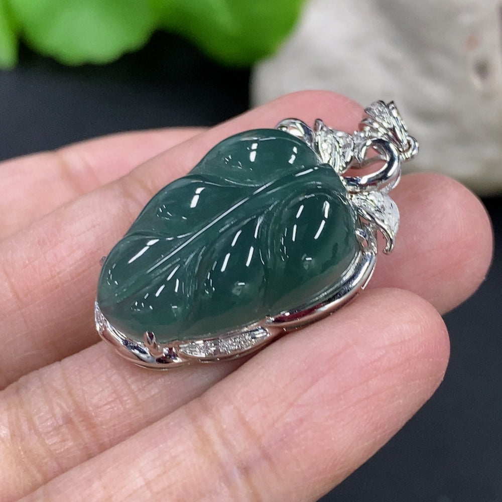 Jadeite leaf inlay pendant with 18K gold and diamond accents on a delicate necklace chain.