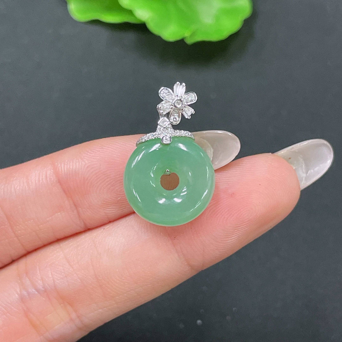 Jadeite pendant with peace knot design in 18k gold inlaid with diamonds, crafted by HUILIU HQ.