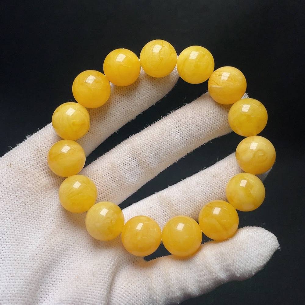 Amber beeswax bracelet by HUILIU HQ with 14.1mm beads, weighs approximately 23.8g, showcasing warm amber tones and handcrafted details.