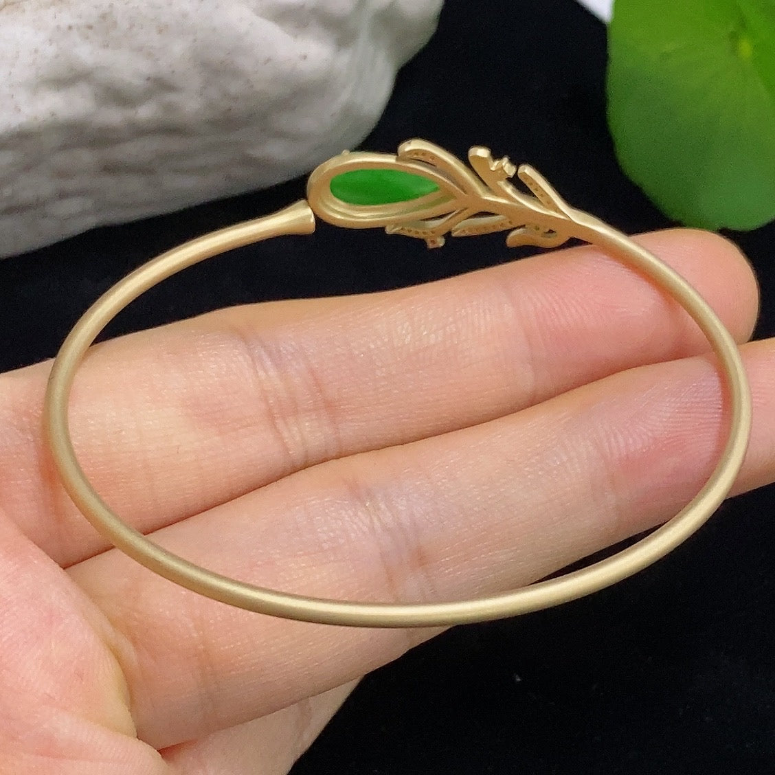 Jadeite bangle in 18K gold with sparkling colorless diamond accents, showcasing elegant jewelry craftsmanship.